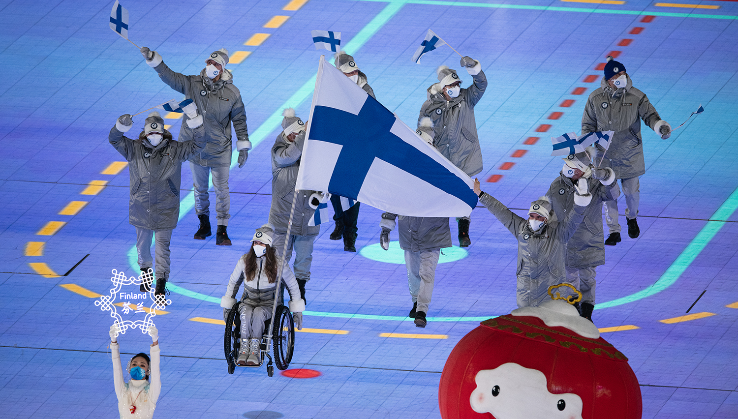 Kuva Pekingin avajaistilaisuudesta, jossa Maiju ja Inkki lipunkantajina.